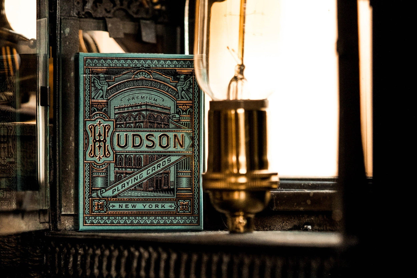 Green Hudson Playing Cards packaging with vintage lamp in the background.