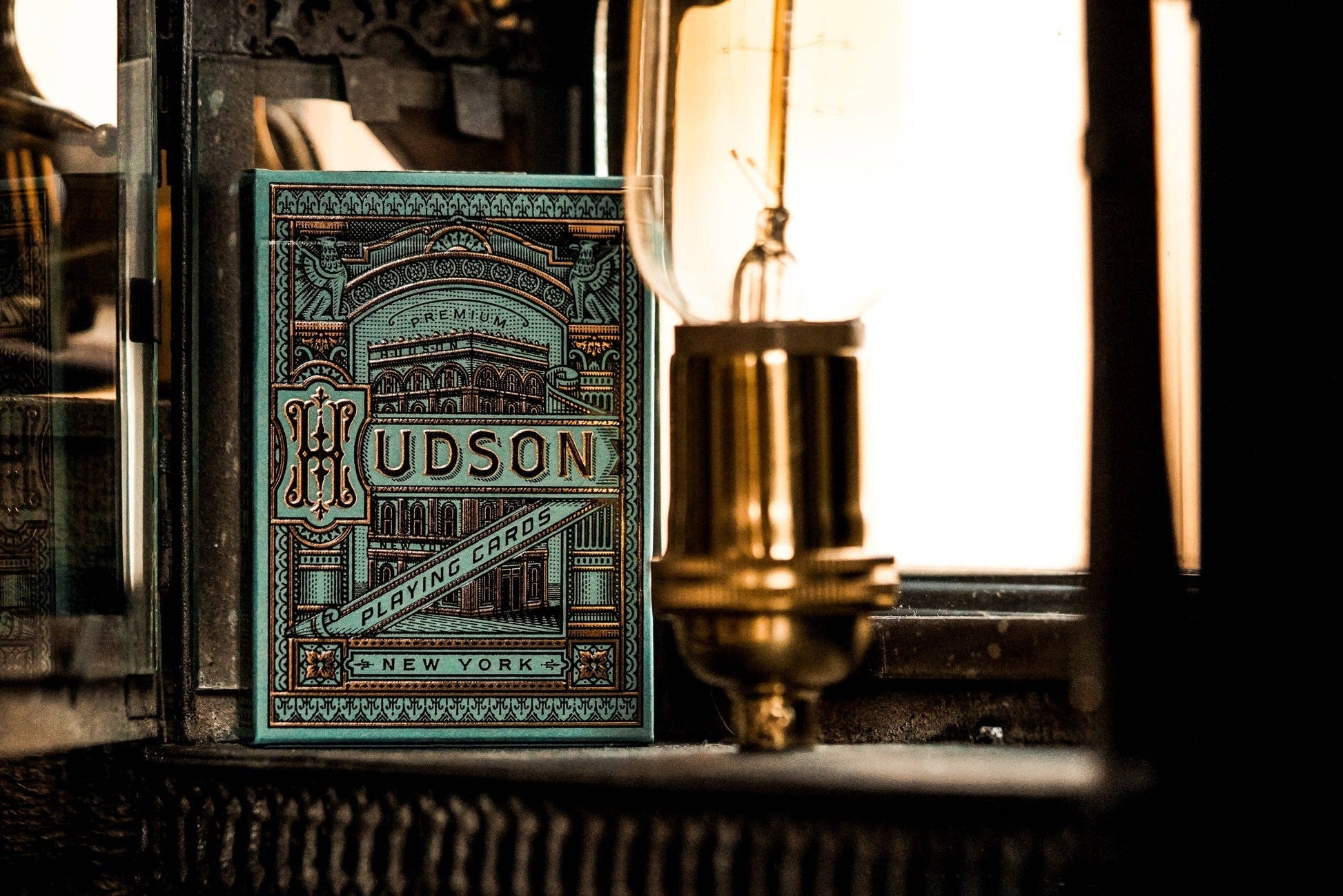 Green Hudson Playing Cards packaging with vintage lamp in the background.